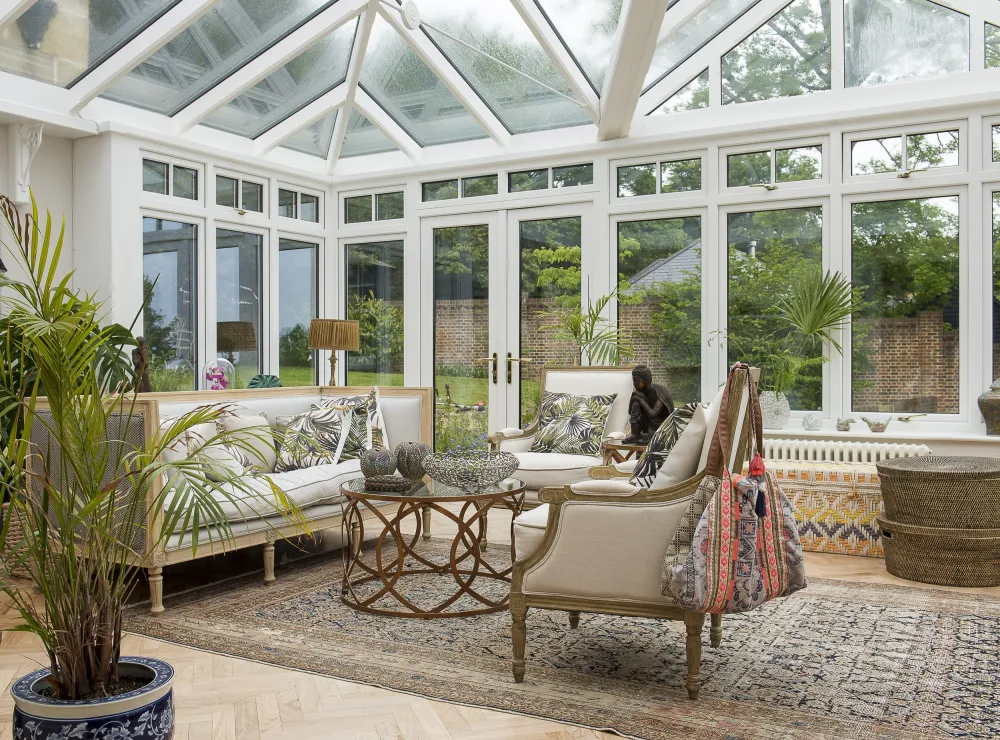 Conservatory with seating, table, carpet and house plants