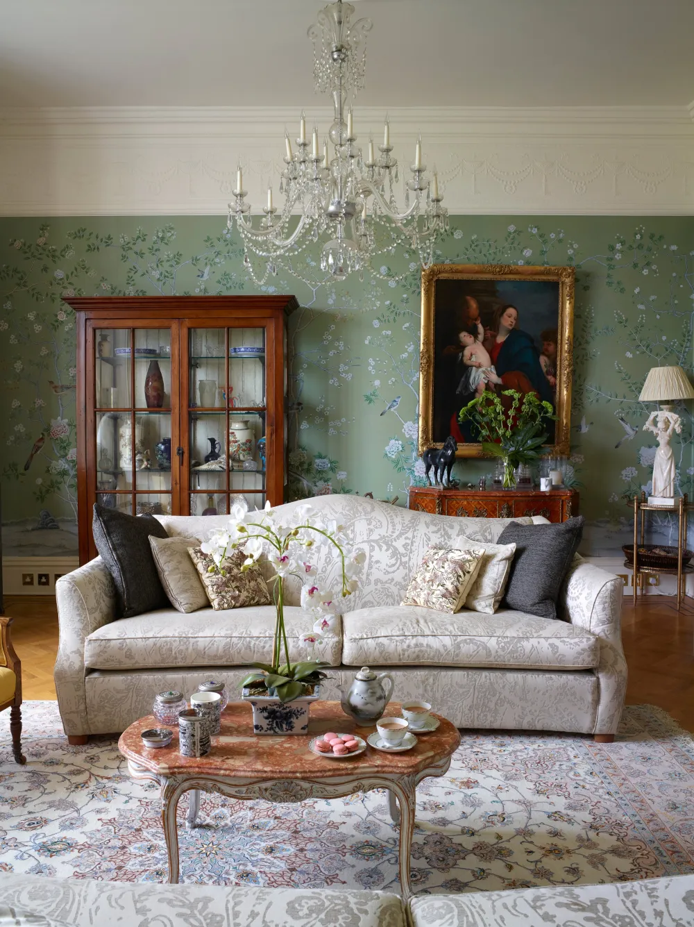 Drawing room with sofa, coffee table and green chinoiserie wallpaper