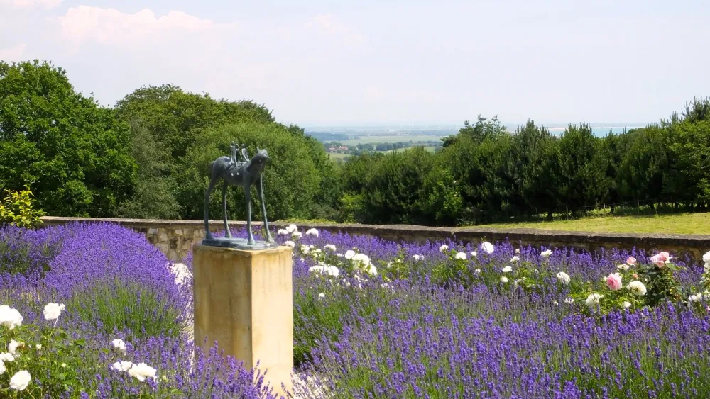 Rose and lavender garden with sculpture of horse and children by Dawn Benson